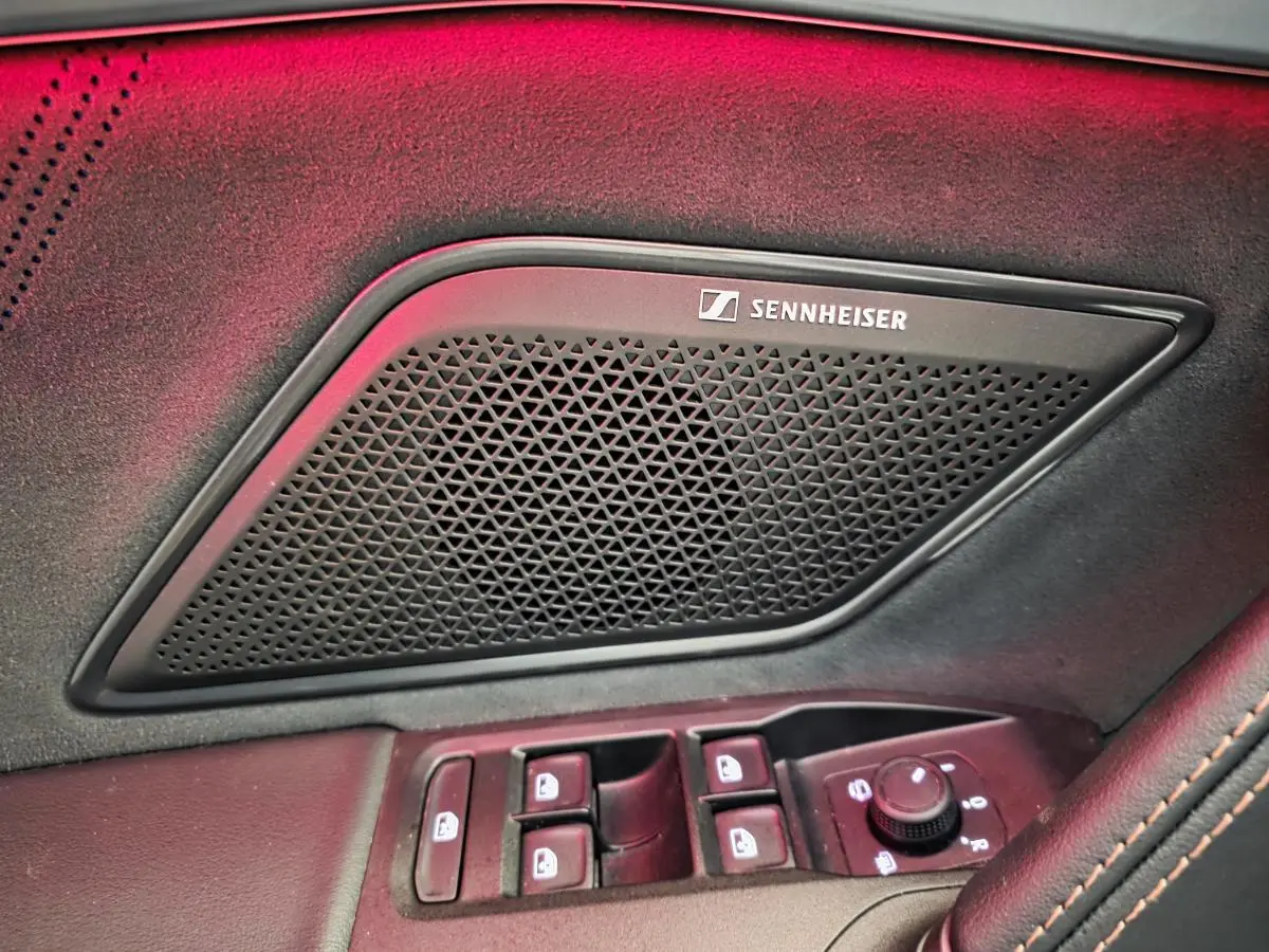 Gros plan sur la porte côté conducteur du CUPRA Formentor blanc, avec haut-parleur Sennheiser et commandes de vitres.