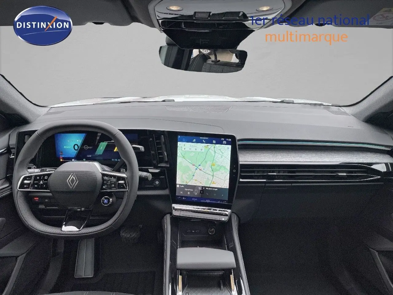 Vue intérieure avant du Renault Austral E-Tech blanc nacré, mettant en valeur le tableau de bord numérique et l'écran tactile central.