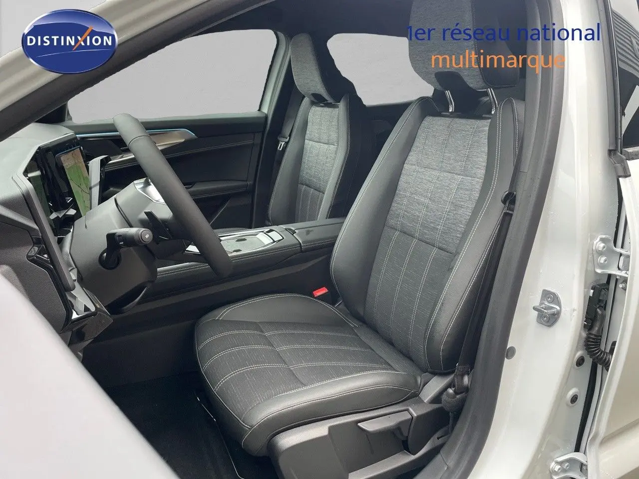 Vue intérieure côté conducteur du Renault Austral 2024 blanc nacré, sièges tissu gris et cuir noir avec surpiqûres blanches.
