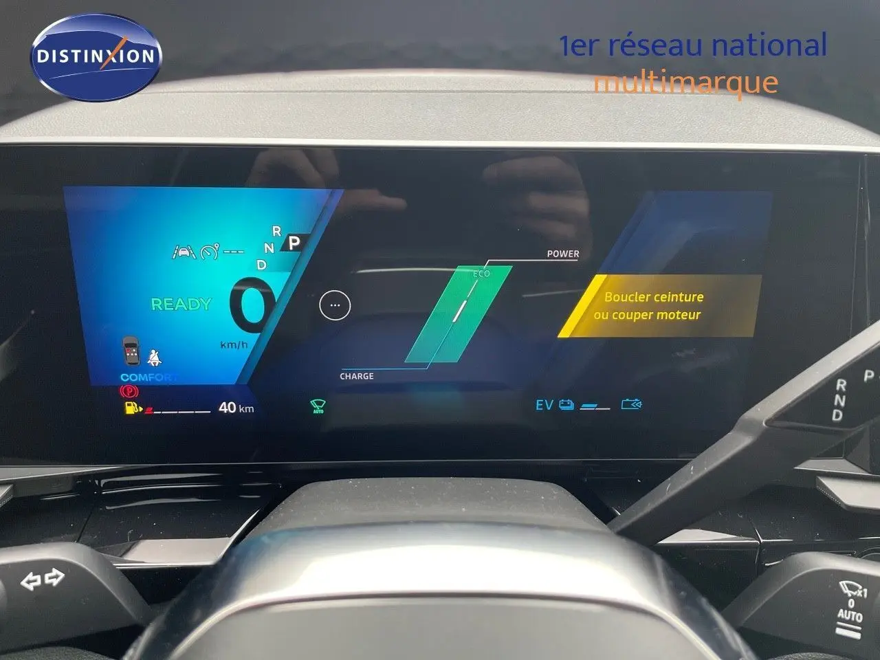 Tableau de bord numérique du Renault Austral E-Tech blanc nacré, affichant la vitesse et alertes, vue frontale intérieure.