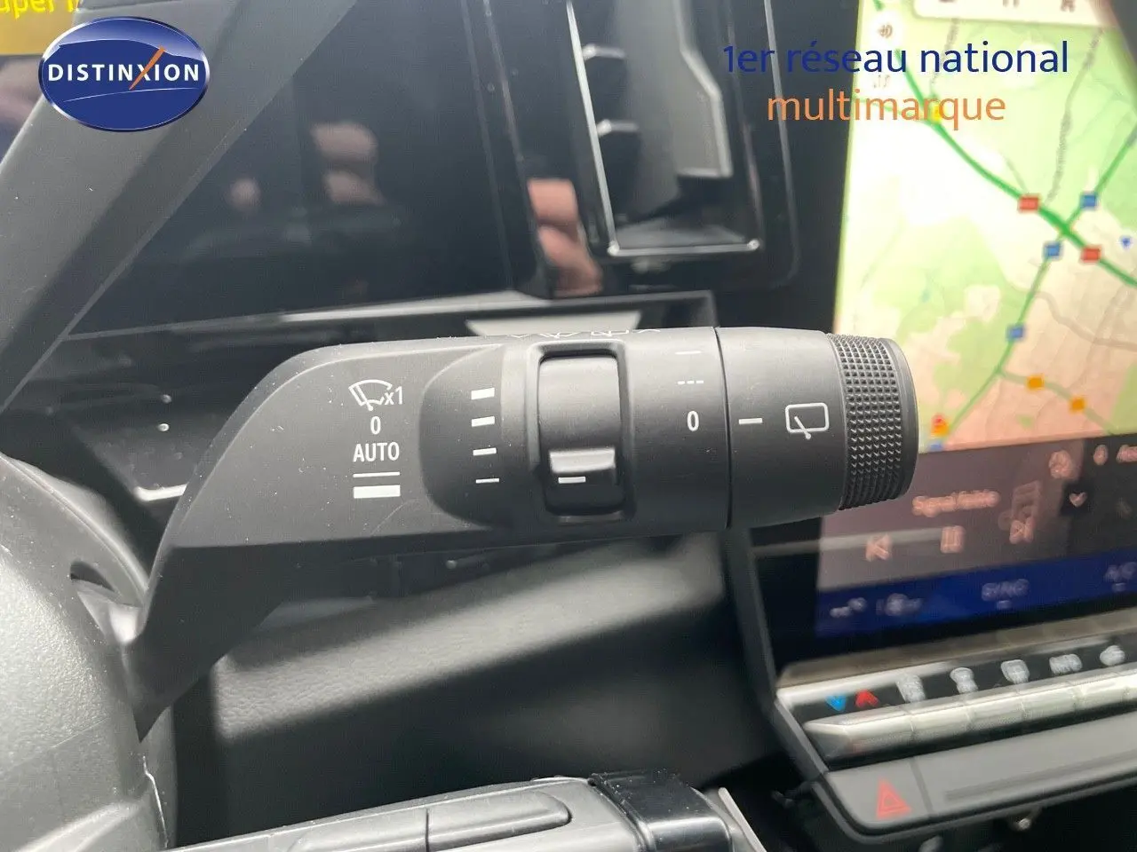 Gros plan sur la commande d'essuie-glace à gauche du volant dans l'habitacle du Renault Austral blanc nacré 2024.