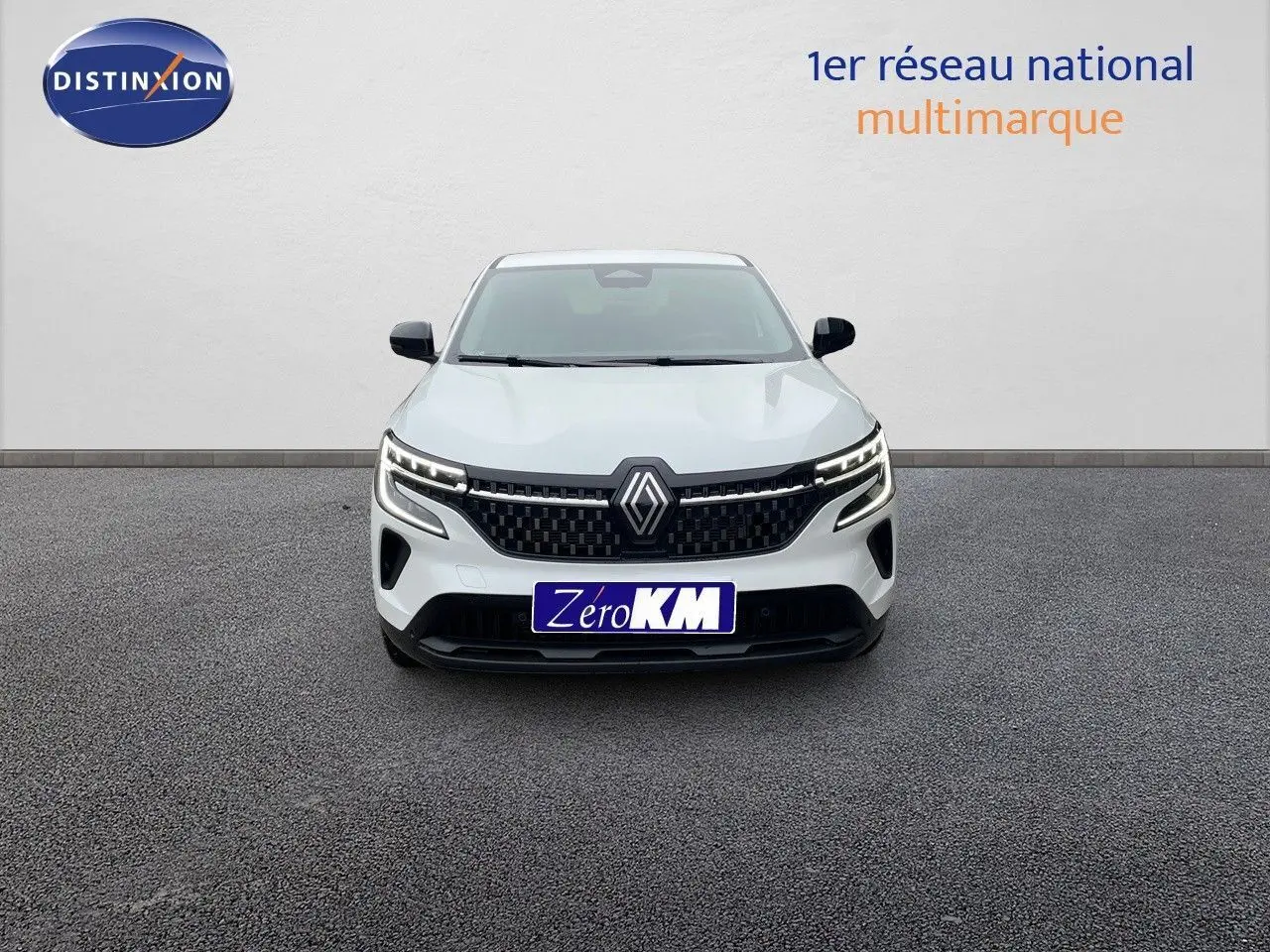 Vue frontale d'un Renault Austral blanc nacré avec calandre noire et feux LED allumés sur fond neutre.