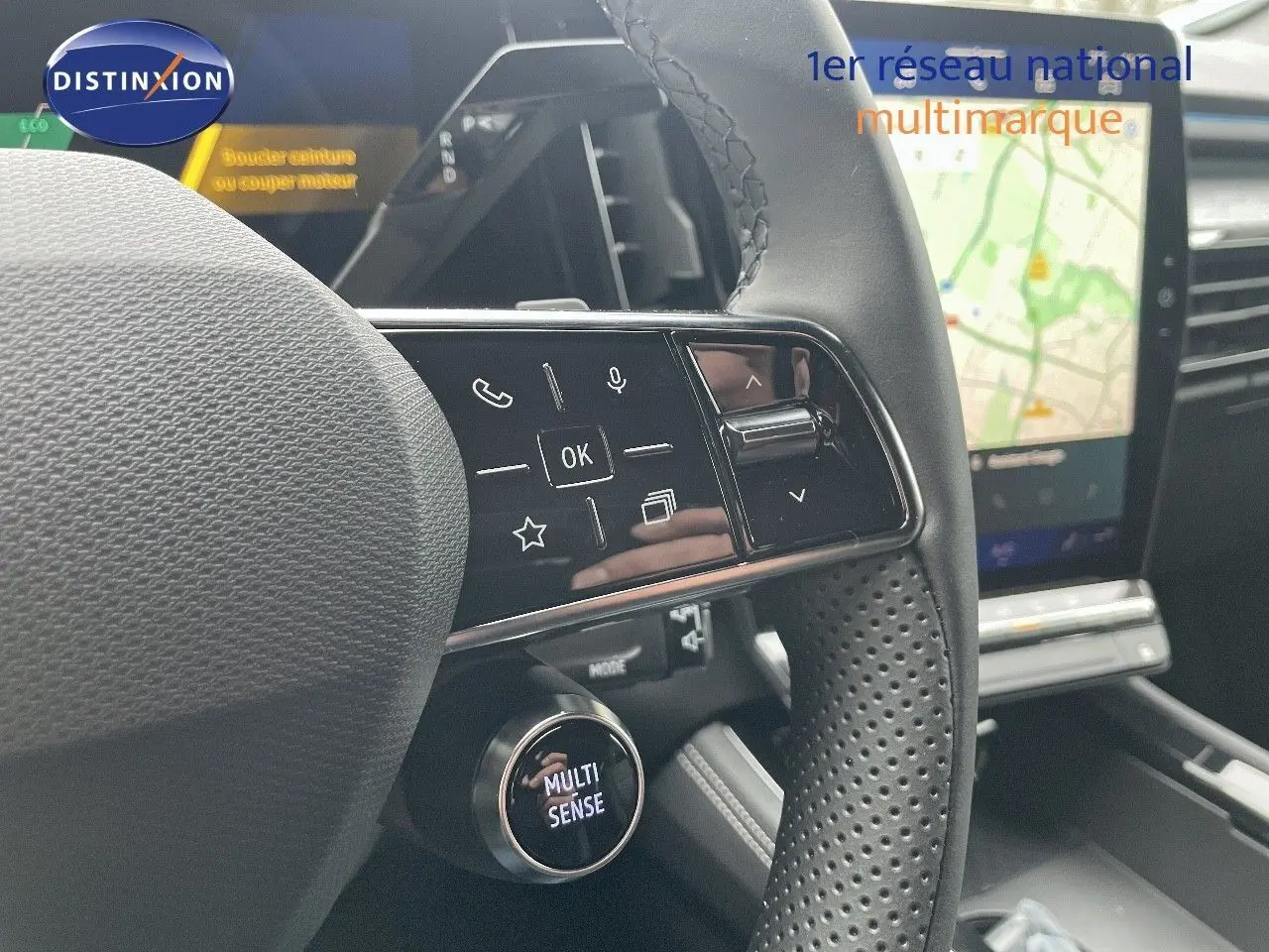 Gros plan sur le volant perforé du Renault Austral blanc nacré, avec commandes tactiles et bouton Multi Sense visible.