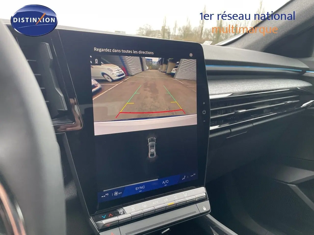 Vue intérieure du tableau de bord du Renault Austral blanc nacré 2024 avec écran tactile affichant la caméra de recul.