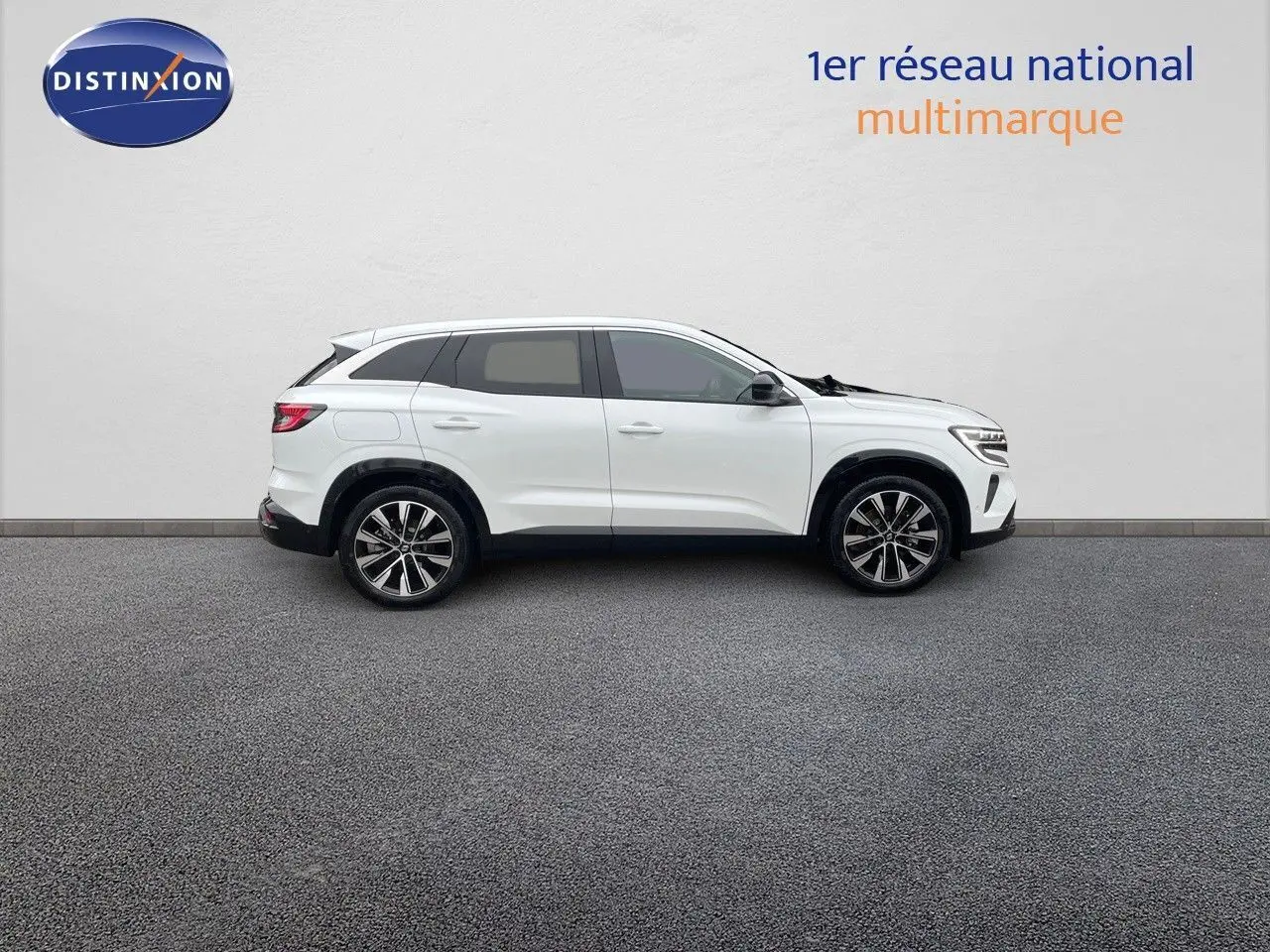 Profil côté droit d'un Renault Austral blanc nacré 2024 hybride, avec jantes bi-ton et lignes épurées.