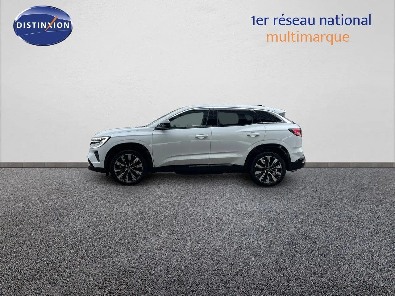Profil côté gauche d'un Renault Austral blanc nacré 2024 hybride avec jantes bi-ton et lignes épurées.