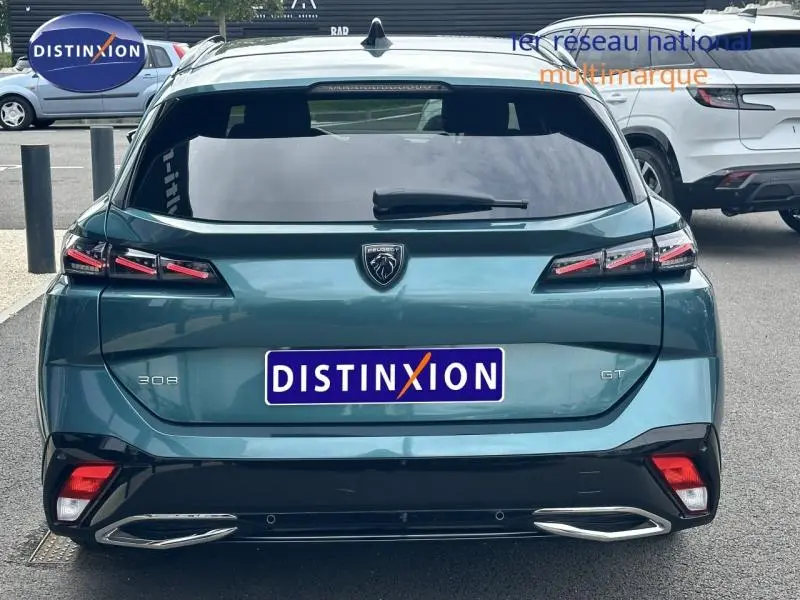 Vue arrière d'une Peugeot 308 SW GT bleu métallisé avec feux LED et double sortie d'échappement chromée.
