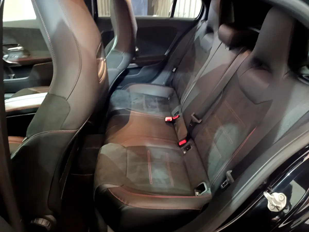Vue intérieure côté droit sur la banquette arrière en cuir noir avec surpiqûres rouges d'une Mercedes Classe A 180 AMG Line 2019.