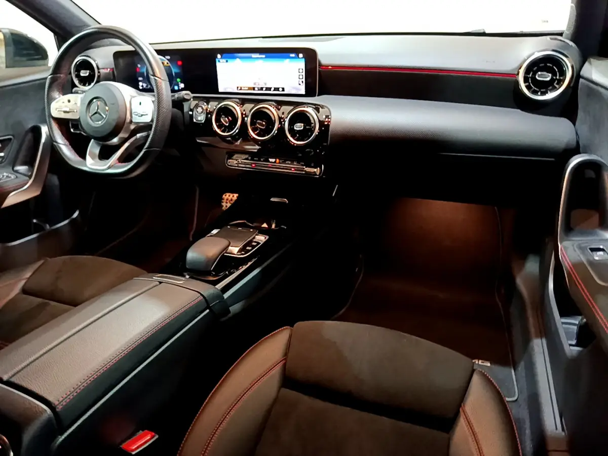 Intérieur noir de la Mercedes Classe A 180 AMG Line 2019 vu côté passager, avec tableau de bord digital et volant multifonctions.