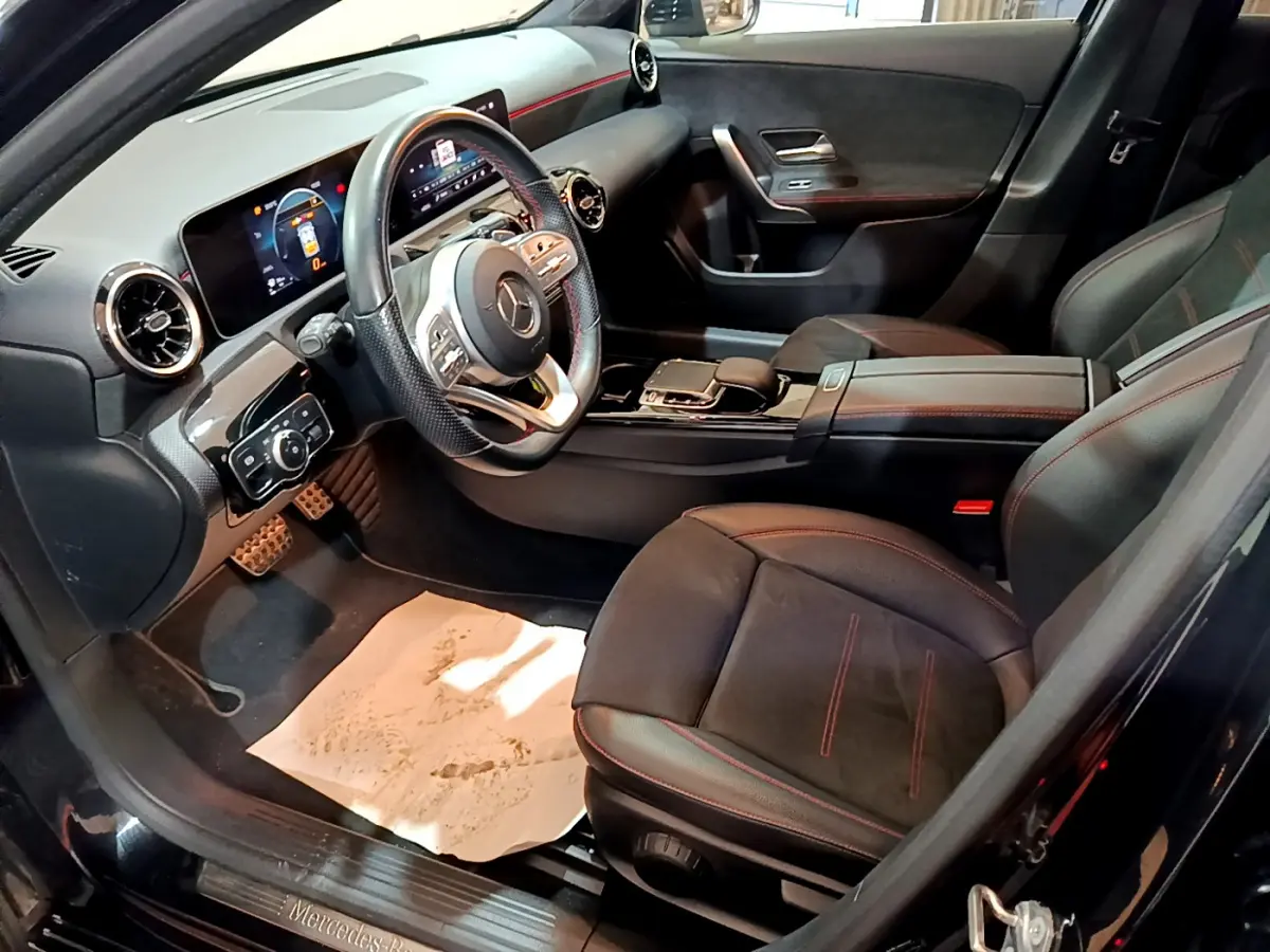 Intérieur noir de la Mercedes Classe A 180 AMG Line 2019 vu côté conducteur, volant cuir et tableau de bord digital.