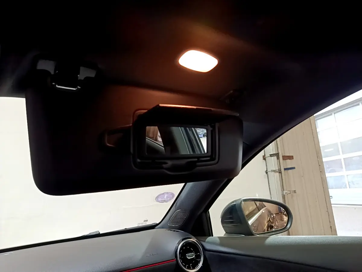 Intérieur noir de la Mercedes Classe A 180 AMG Line 2019, vue sur pare-soleil avec miroir et rétro côté droit.