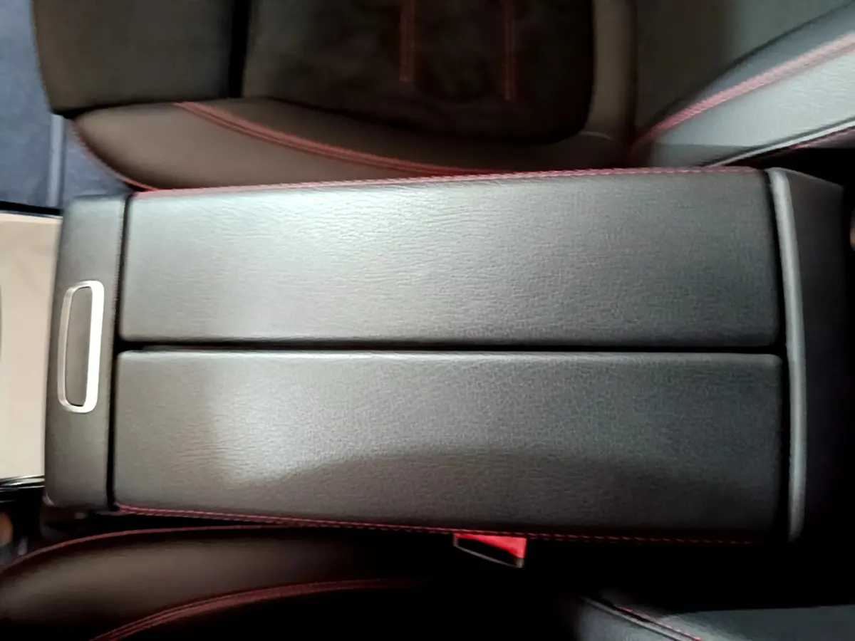 Gros plan sur l'accoudoir central en cuir noir avec surpiqûres rouges de la Mercedes Classe A 180 AMG Line 2019.