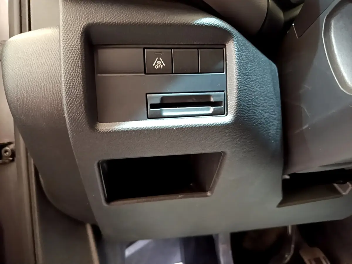 Détail intérieur côté gauche sous le tableau de bord du Citroën C5 Aircross 2020, avec bouton de désactivation d’aide à la conduite.