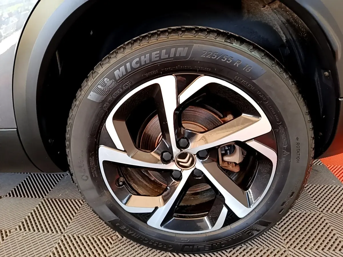 Gros plan sur la roue avant droite du Citroën C5 Aircross gris foncé, avec jante alliage bicolore et pneu Michelin.