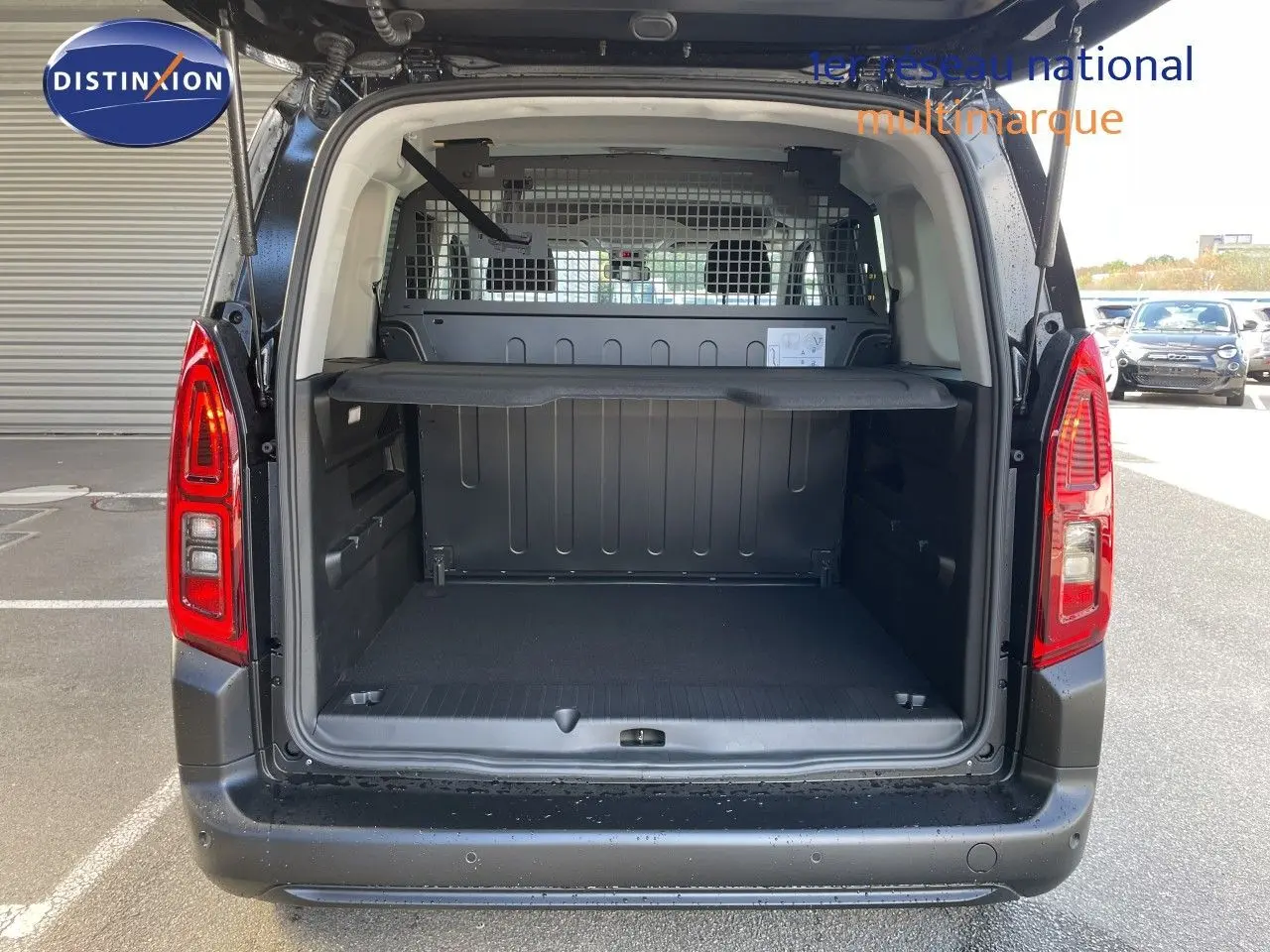 Vue arrière ouverte du Citroën Berlingo noir Perla Nera, montrant l'espace de chargement avec cloison métallique.