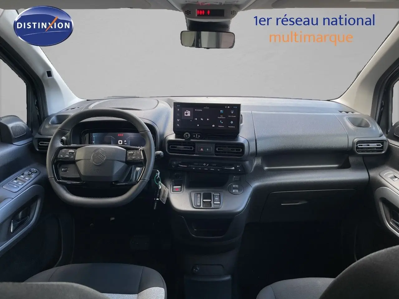 Vue intérieure avant du Citroën Berlingo 2026, tableau de bord noir avec écran tactile et volant multifonction.