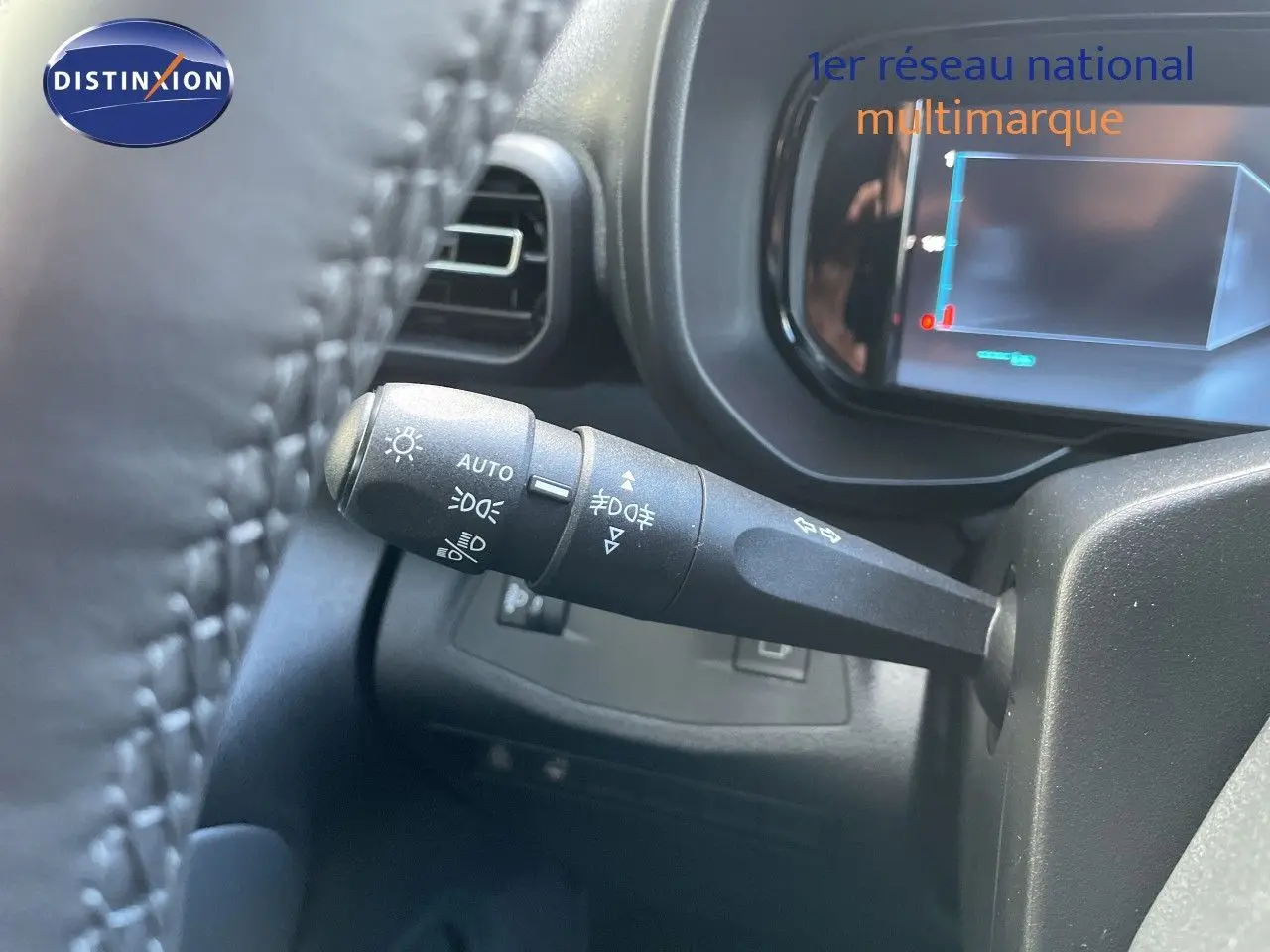 Gros plan sur la manette de commande d’éclairage à gauche du volant dans un Citroën Berlingo noir Perla Nera 2026.