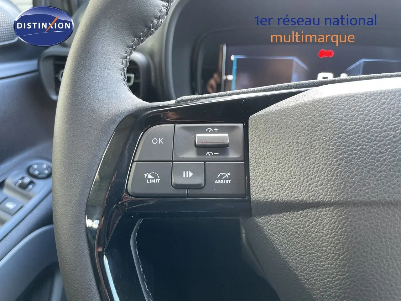 Gros plan sur les commandes à gauche du volant en cuir noir du Citroën Berlingo MPV M 2026, intérieur noir.