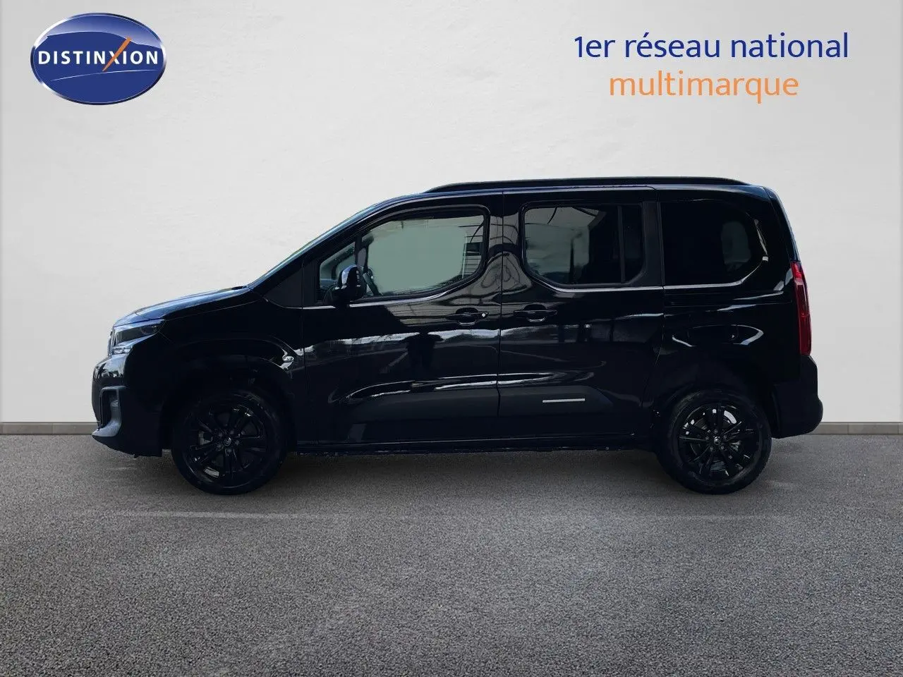 Profil gauche d'un Citroën Berlingo noir Perla Nera métal avec jantes noires, sur fond clair en intérieur.