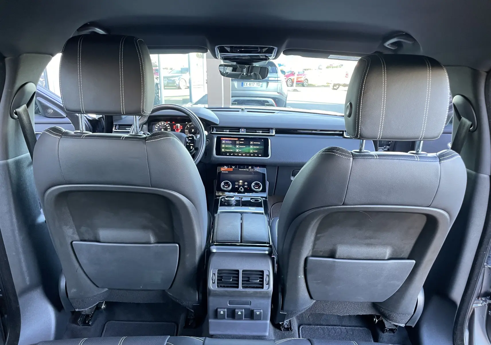 Vue arrière de l'intérieur du Range Rover Velar D240 S R-Dynamic 2018 en cuir noir avec tableau de bord digital.