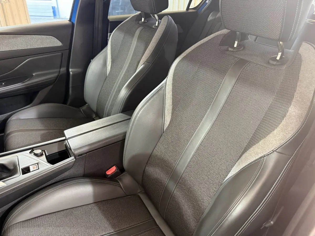 Vue rapprochée des sièges avant en tissu et cuir noir de la Peugeot 308 PureTech 130 S&S Allure Pack 2023.