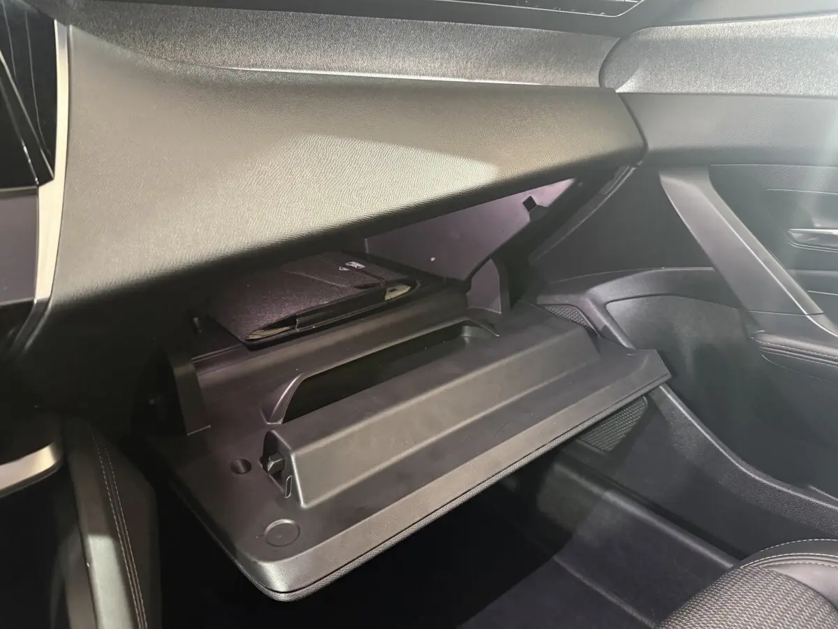 Gant de boîte à gants ouverte côté passager dans l'habitacle noir du Peugeot 308 bleu 2023 PureTech 130 S&S Allure Pack.