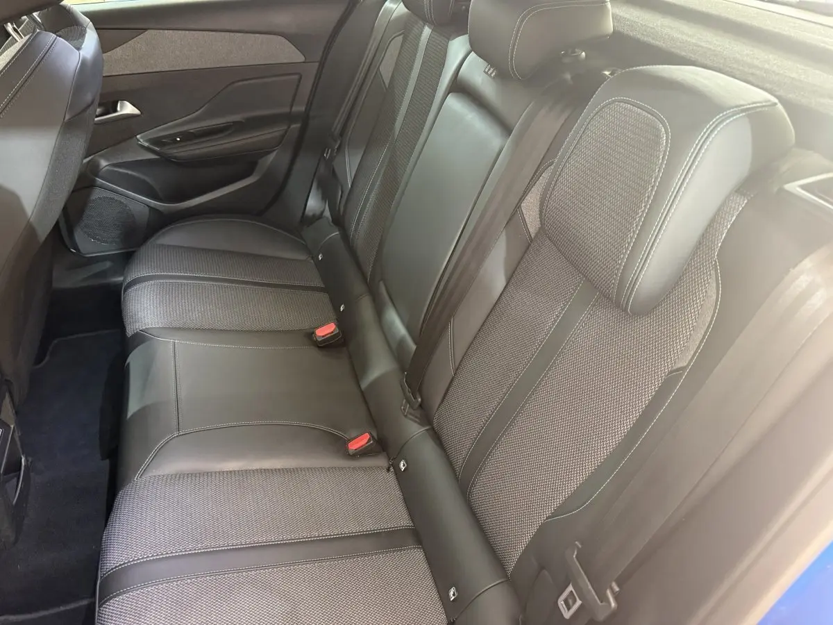Vue côté droit de la banquette arrière en cuir et tissu gris de la Peugeot 308 PureTech 130 2023 bleu.