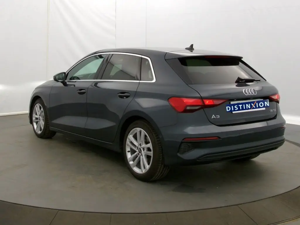 Audi A3 Sportback gris Manhattan vue 3/4 arrière droit, avec feux arrière LED et jantes alliage.