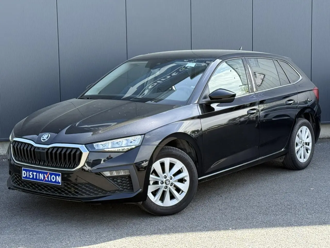 Vue 3/4 avant droite d'une Skoda Scala noire Magic Perle avec jantes alliage et calandre chromée.
