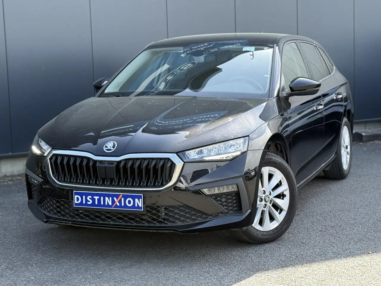 Vue 3/4 avant droite d'une Skoda Scala noire Magic Perle avec calandre chromée et jantes alliage 16 pouces.