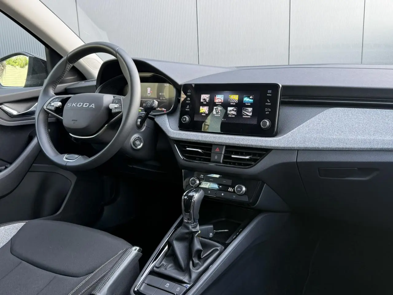 Vue intérieure côté conducteur du Skoda Scala TSI 116 DSG7, volant cuir, écran tactile 8,25 pouces et console centrale noire.