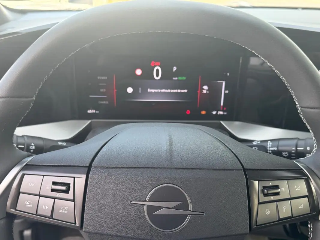 Vue intérieure centrée sur le volant noir de l'Opel Mokka électrique 2025 avec tableau de bord numérique allumé.