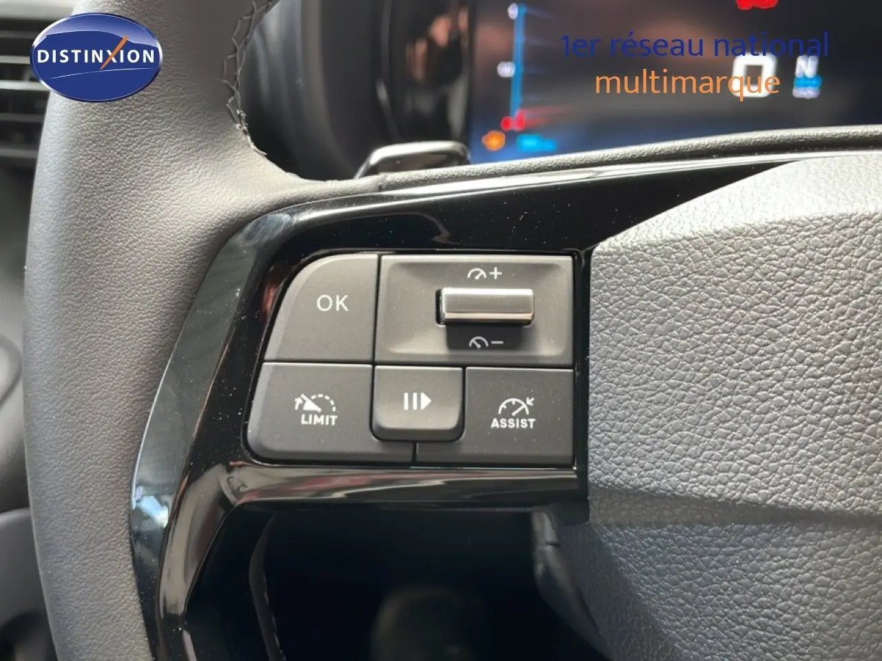 Gros plan sur les commandes au volant du Citroën Berlingo gris, montrant les boutons de régulateur et limitateur de vitesse.