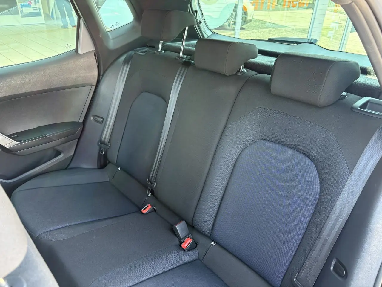 Vue intérieure du siège arrière côté gauche de la SEAT Arona 2024 avec sellerie textile noire et appuie-têtes.