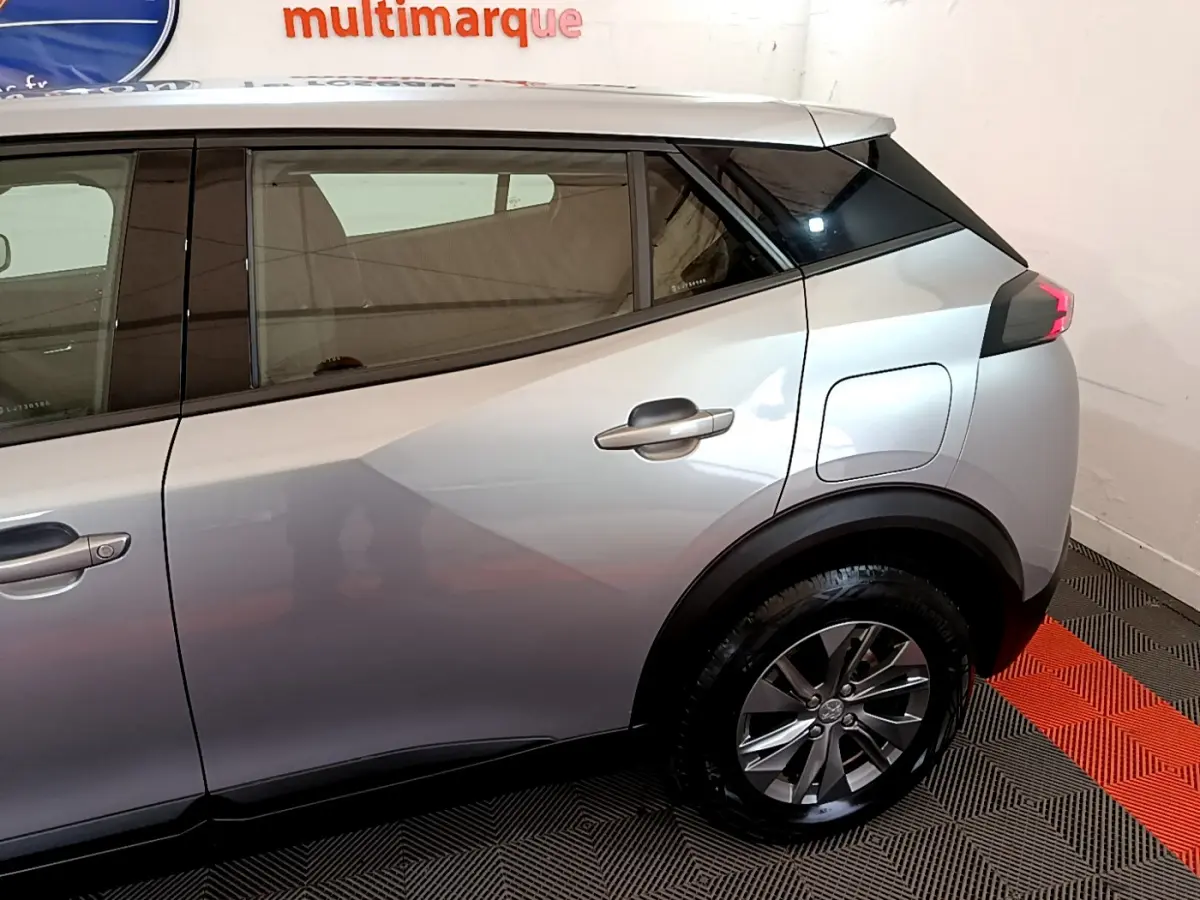 Profil côté droit du Peugeot 2008 gris clair de 2020, mettant en valeur la porte arrière et la roue arrière.