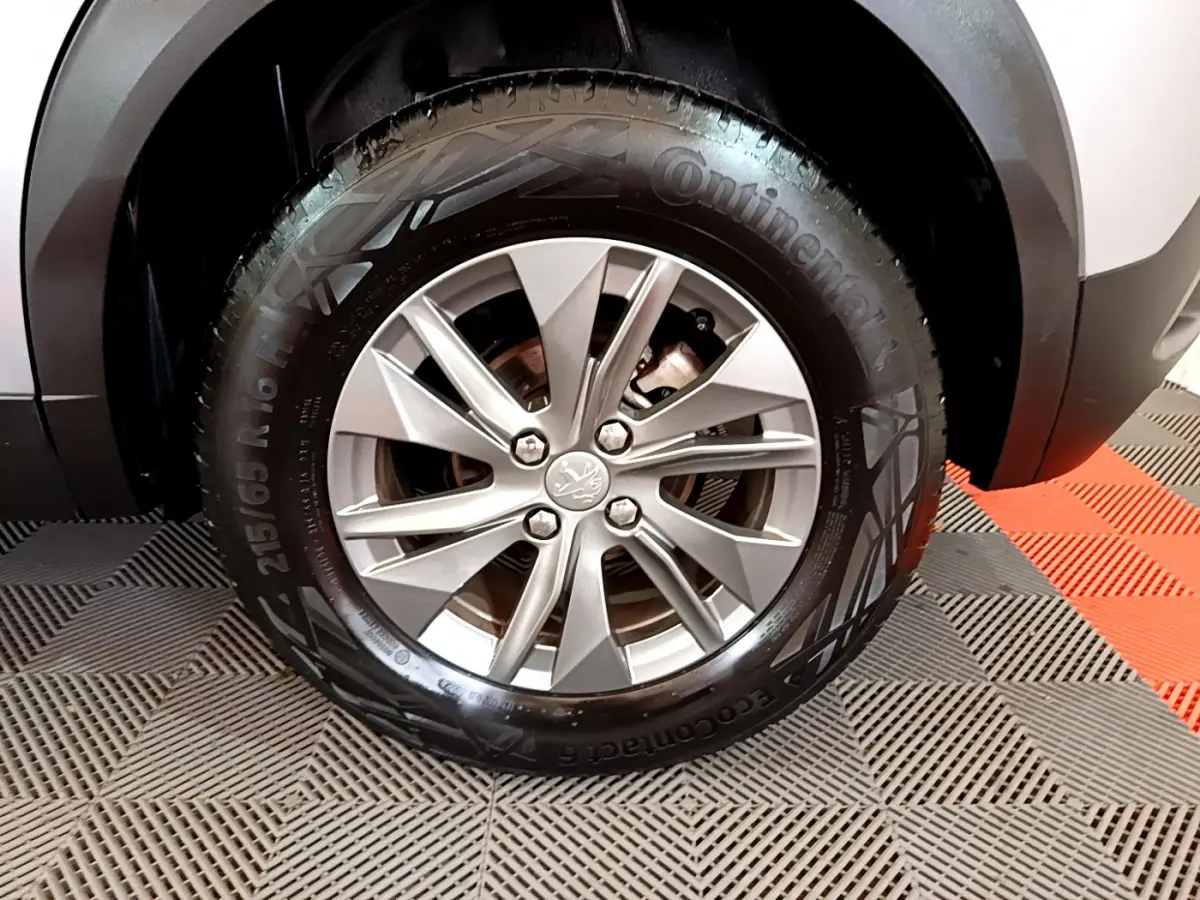Gros plan sur la roue avant droite du Peugeot 2008 gris clair, mettant en valeur la jante alliage et le pneu Continental.