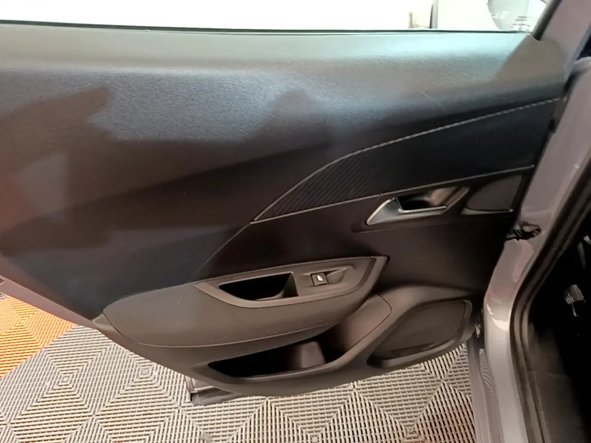 Gros plan sur la porte arrière côté droit gris clair du Peugeot 2008 2020 avec commandes de vitre et poignée intégrée.
