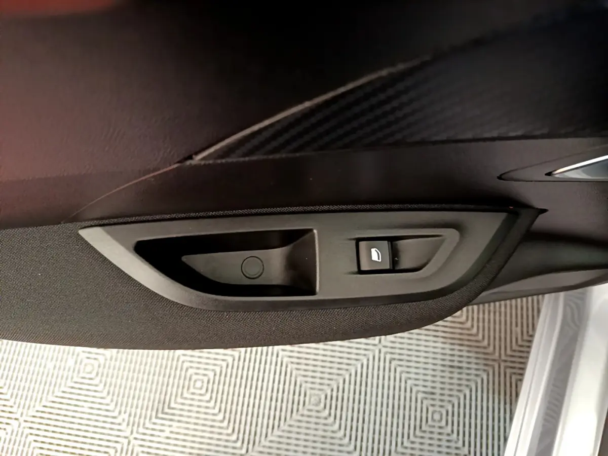 Bouton de verrouillage de porte sur le panneau intérieur côté conducteur d'une Peugeot 2008 gris clair 2020.