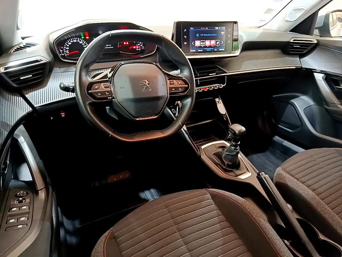 Intérieur de la Peugeot 2008 essence 2020, vue avant centrée sur le volant cuir et l'écran tactile du tableau de bord.