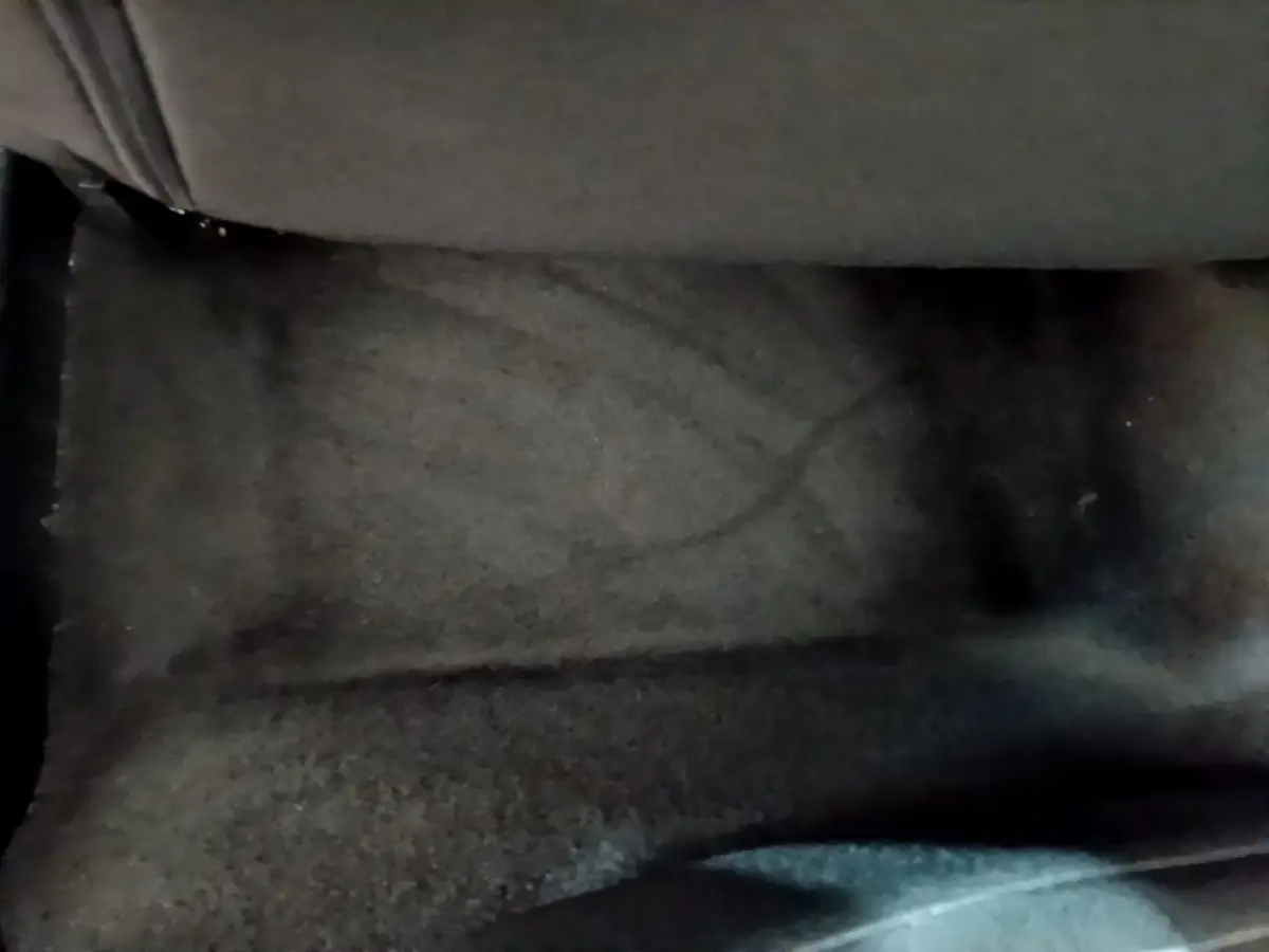 Gros plan sur le tapis de sol noir du côté passager avant d'un Peugeot 2008 gris clair de 2020.