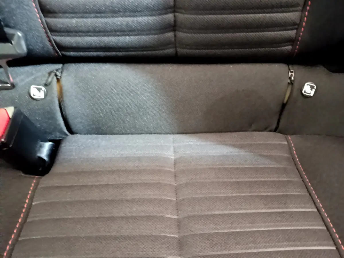 Gros plan sur la banquette arrière noire avec surpiqûres rouges et fixations Isofix du Peugeot 2008.