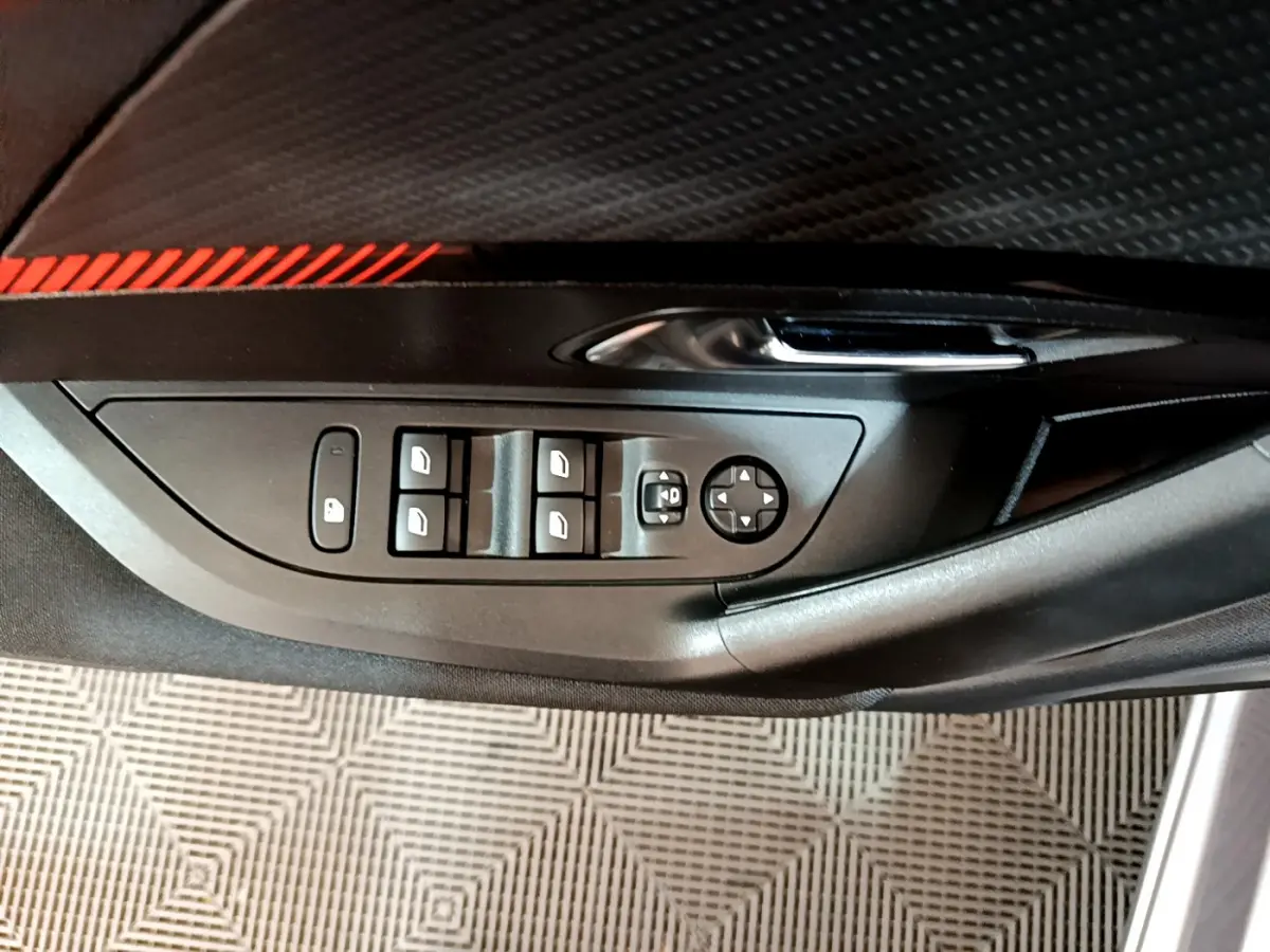 Panneau de porte côté gauche du Peugeot 2008 gris clair, avec commandes des vitres et rétroviseurs électriques.