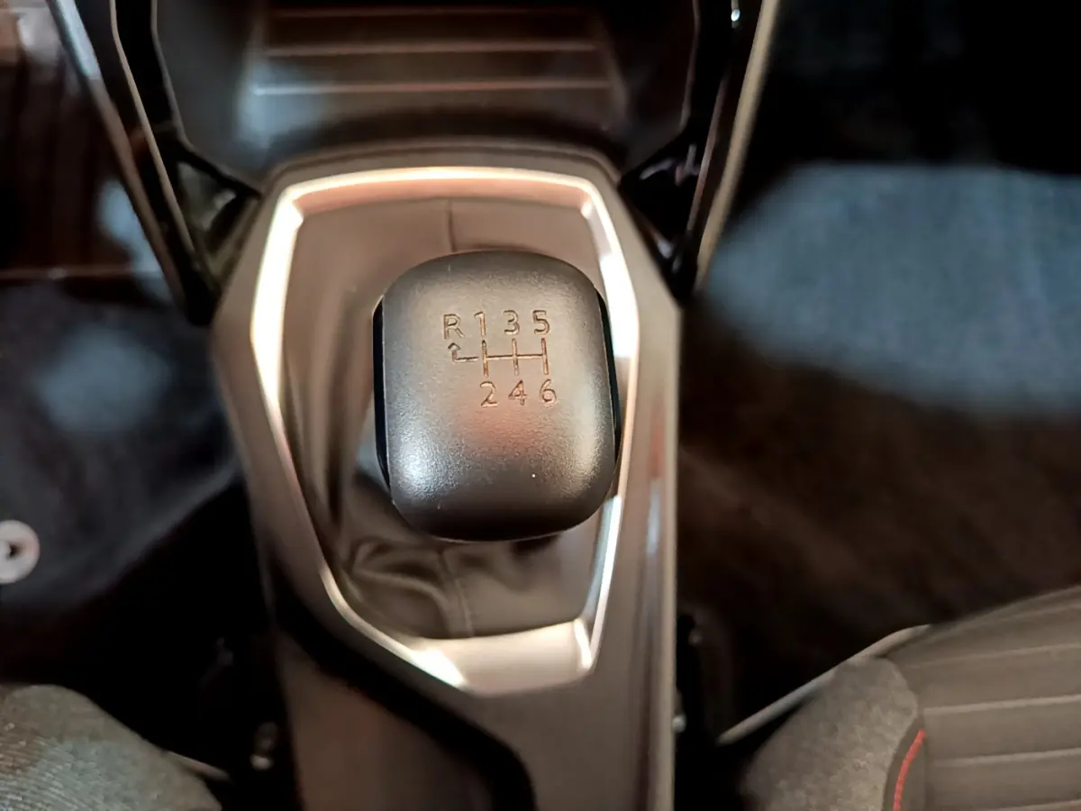 Le levier de vitesses manuel noir vu de dessus dans l'habitacle du Peugeot 2008 gris clair 2020.