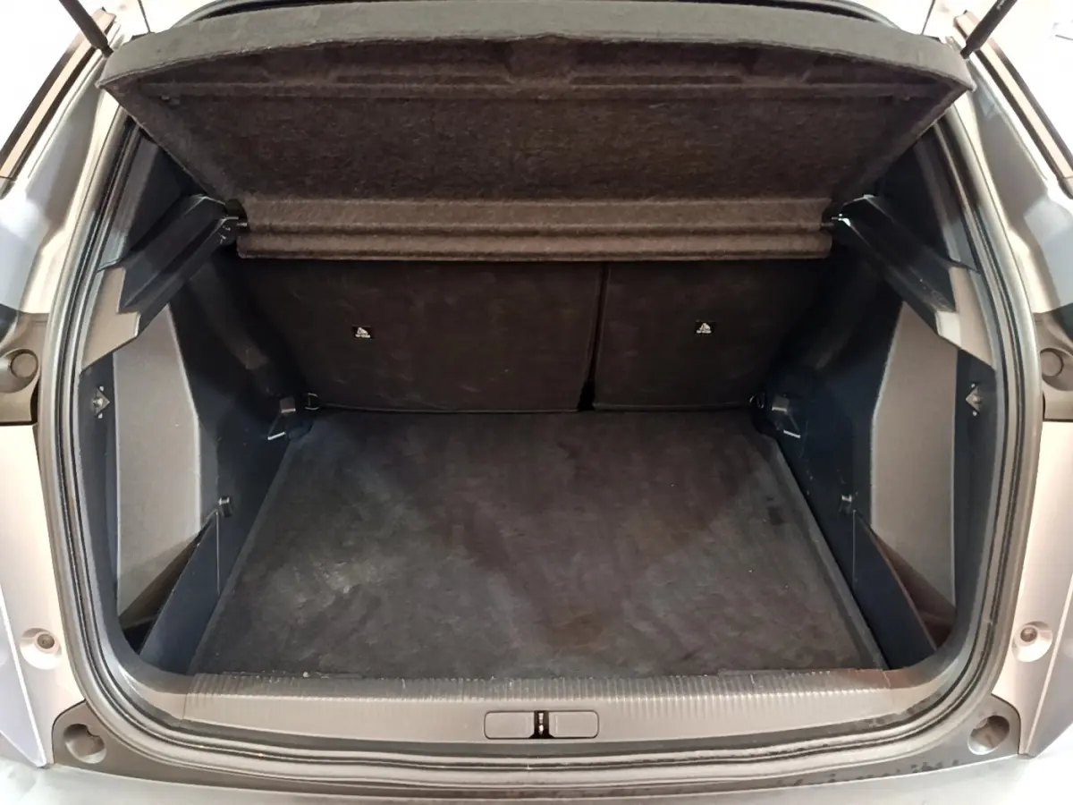 Coffre ouvert vu de l'arrière d'un Peugeot 2008 gris clair, montrant un espace de chargement propre et spacieux.