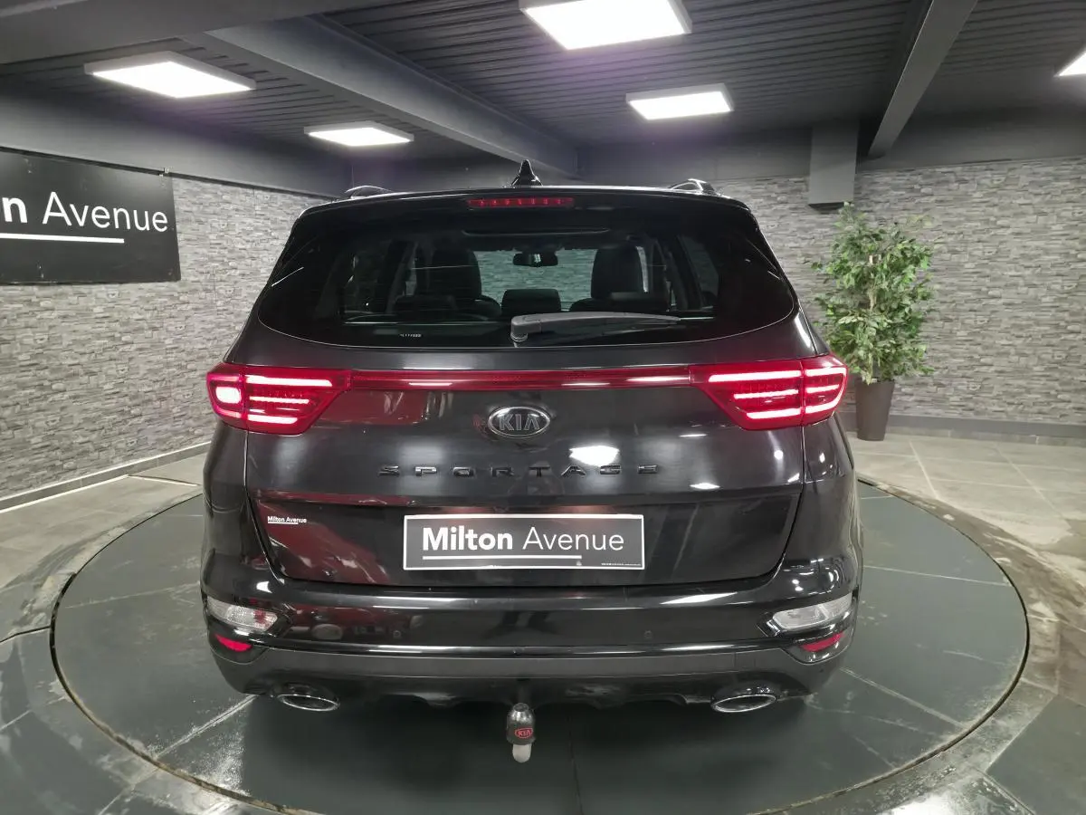 Vue arrière d'un KIA Sportage noir 2021 avec feux LED allumés et double sortie d'échappement chromée.