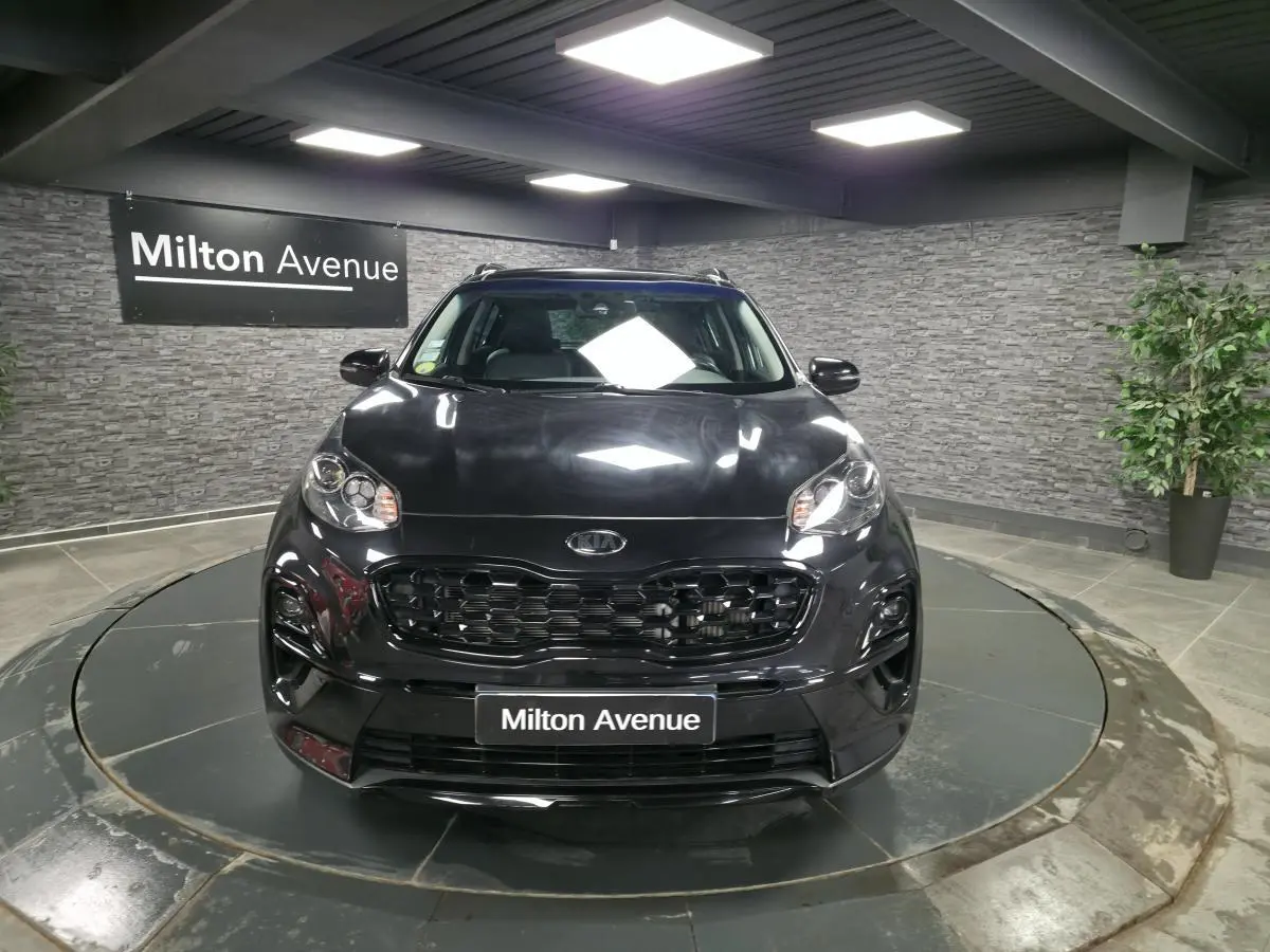 Vue frontale d'un KIA Sportage noir Black Edition 2021 avec calandre noire laquée dans un showroom.
