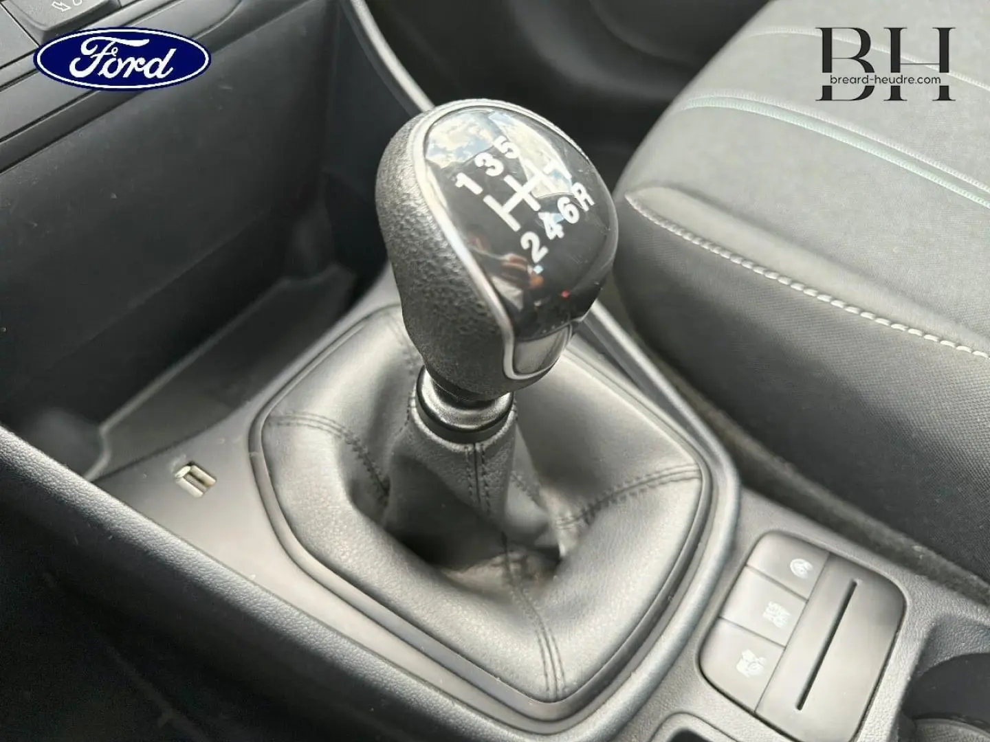 Gros plan sur le levier de vitesses manuel noir et la console centrale d’une Ford Fiesta 2020 avec sièges tissu gris.