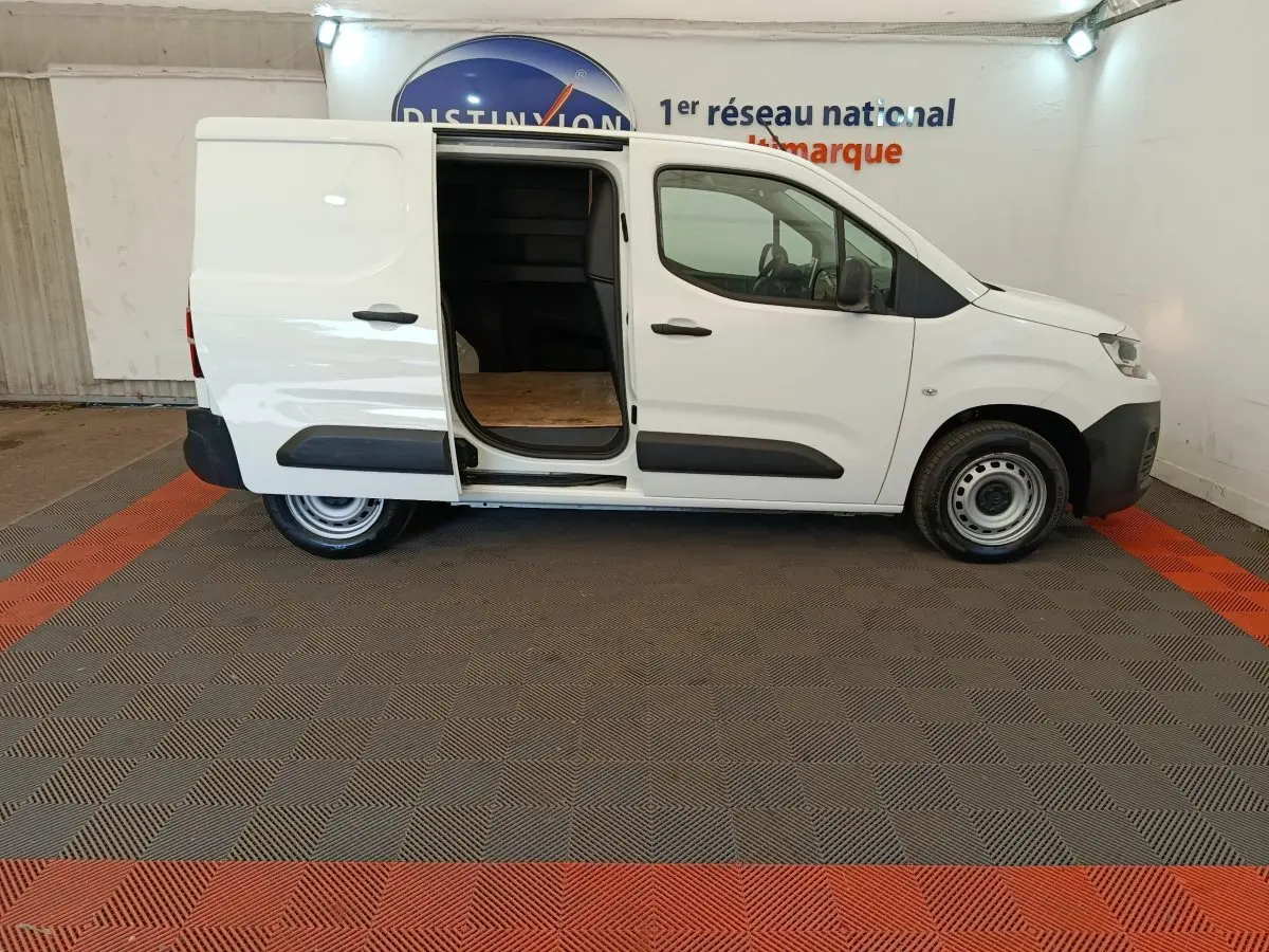 Vue latérale droite d’un utilitaire Citroën Berlingo blanc 2022 avec porte coulissante arrière ouverte, intérieur de chargement visible.