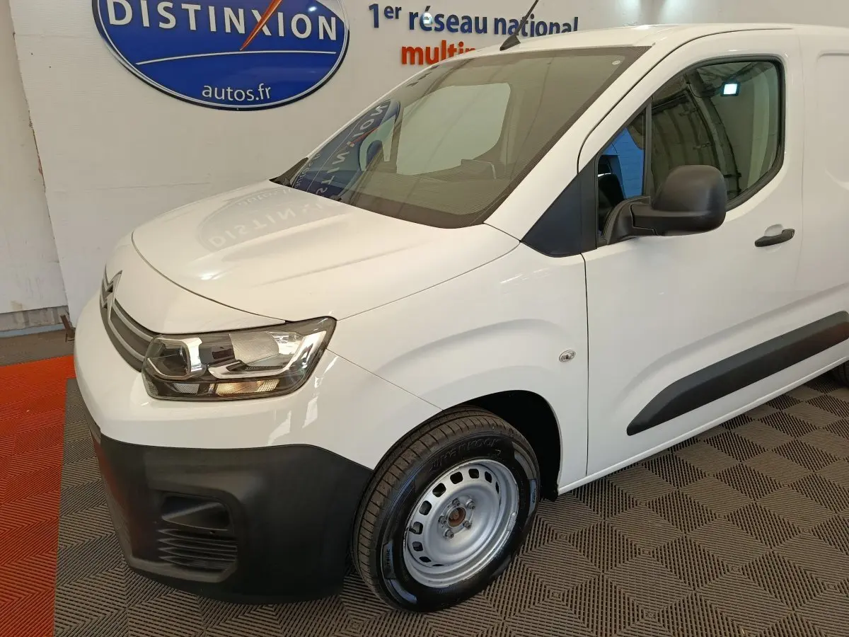 Vue 3/4 avant droit d'un Citroën Berlingo blanc 2022 avec pare-chocs noirs et jantes acier simples.
