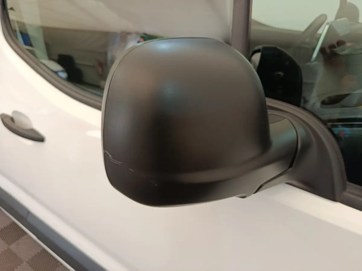 Rétroviseur noir en gros plan côté conducteur du Citroën Berlingo blanc 2022, vue latérale rapprochée.